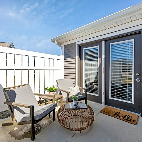 Charming outdoor patio with comfy seating and modern accents, perfect for relaxation and entertaining.