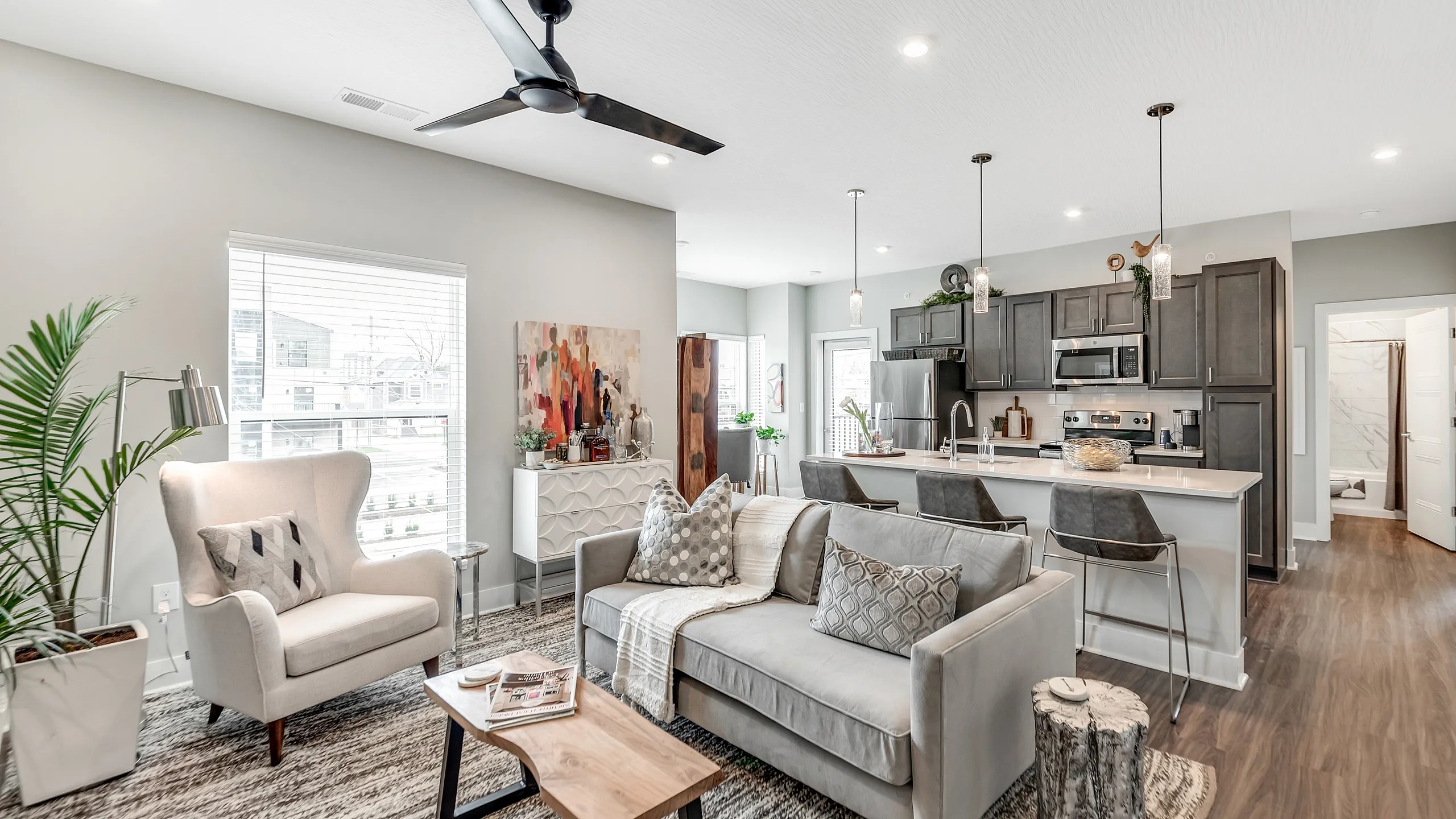 Bright, modern open-concept living room with cozy seating and sleek kitchen, perfect for entertaining.