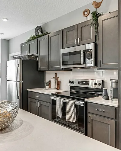 Contemporary kitchen with sleek stainless steel appliances, elegant cabinetry, and a bright, sunlit dining area.