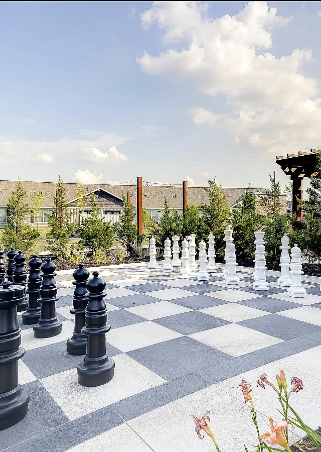 Expansive outdoor area featuring a life-sized chessboard, vibrant garden, and a charming pergola for a perfect blend of play and relaxation.