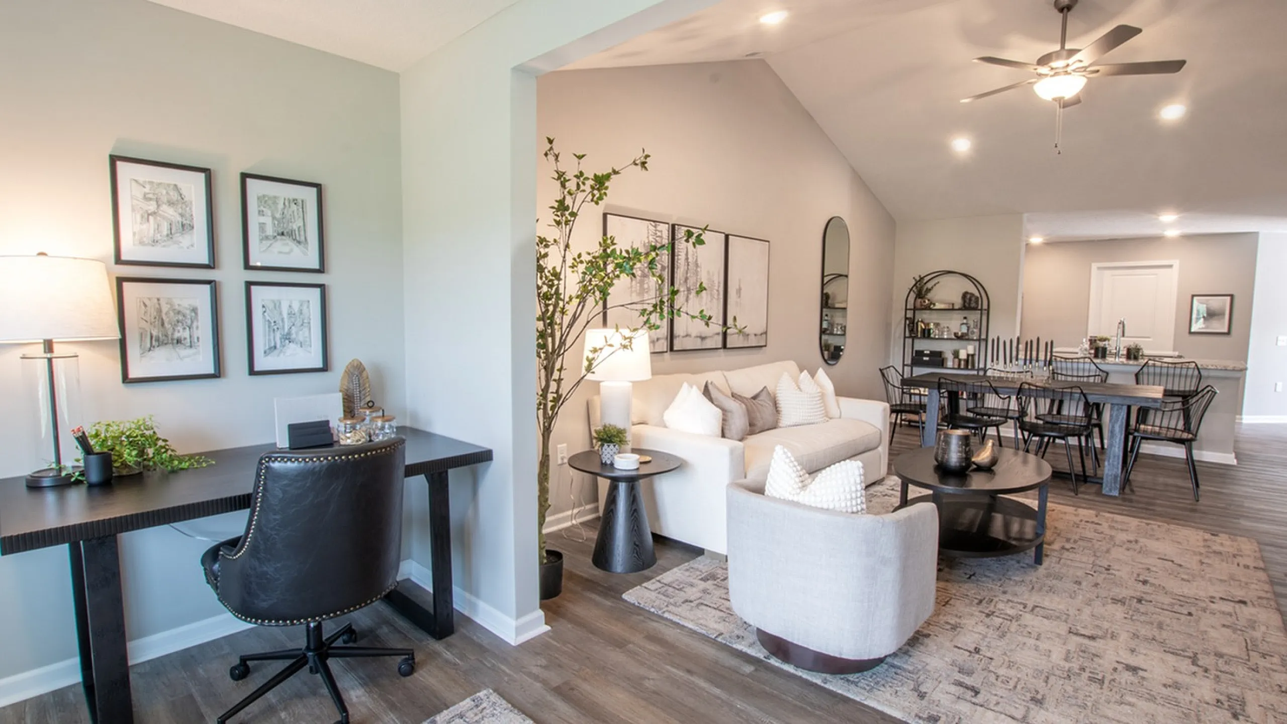 Chic open-concept living room with stylish dining area, modern home office, and elegant decor.