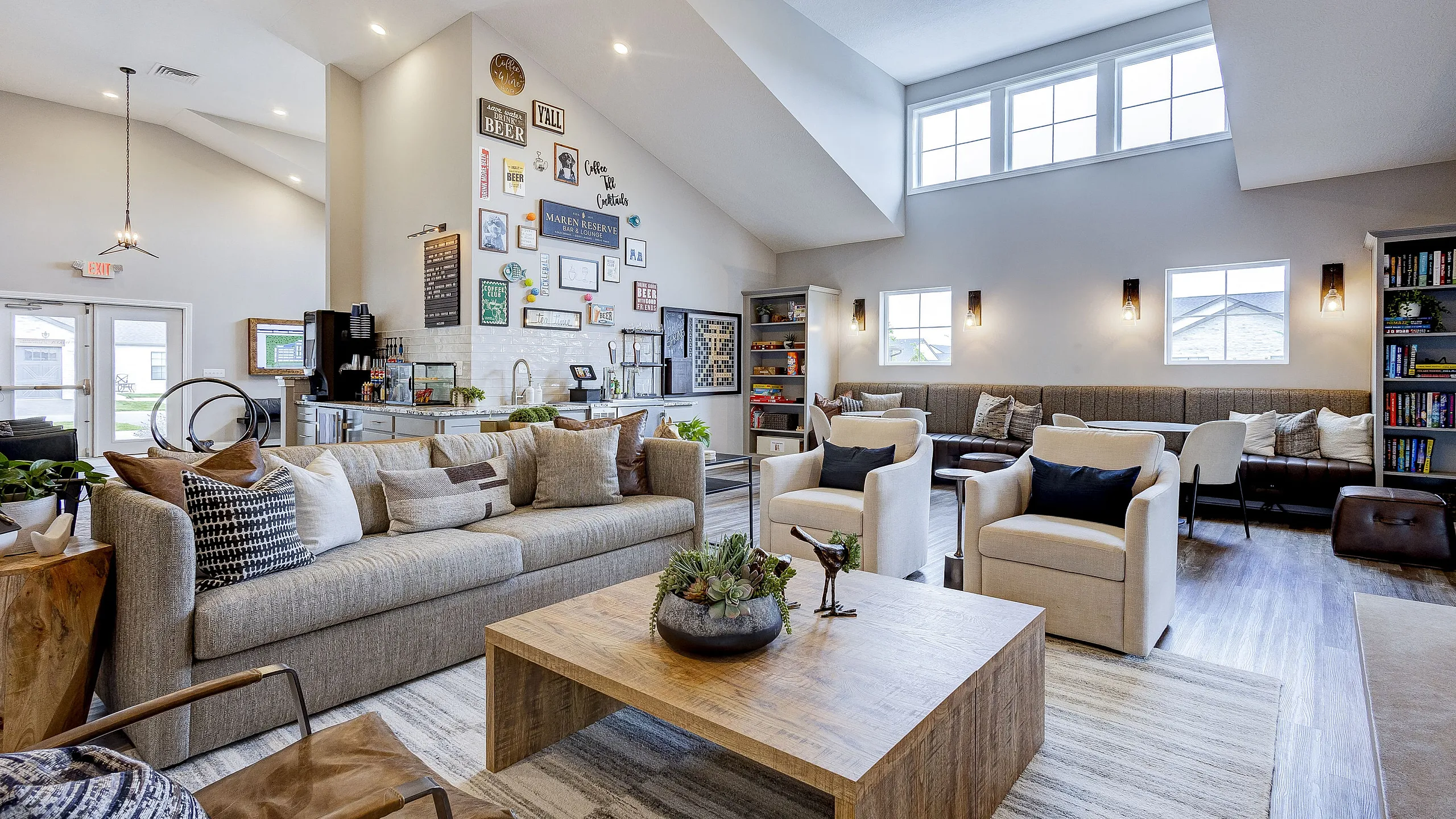 Inviting and spacious living area with modern decor, featuring plush seating, a stylish wooden coffee table, and an accent wall with eclectic artwork.