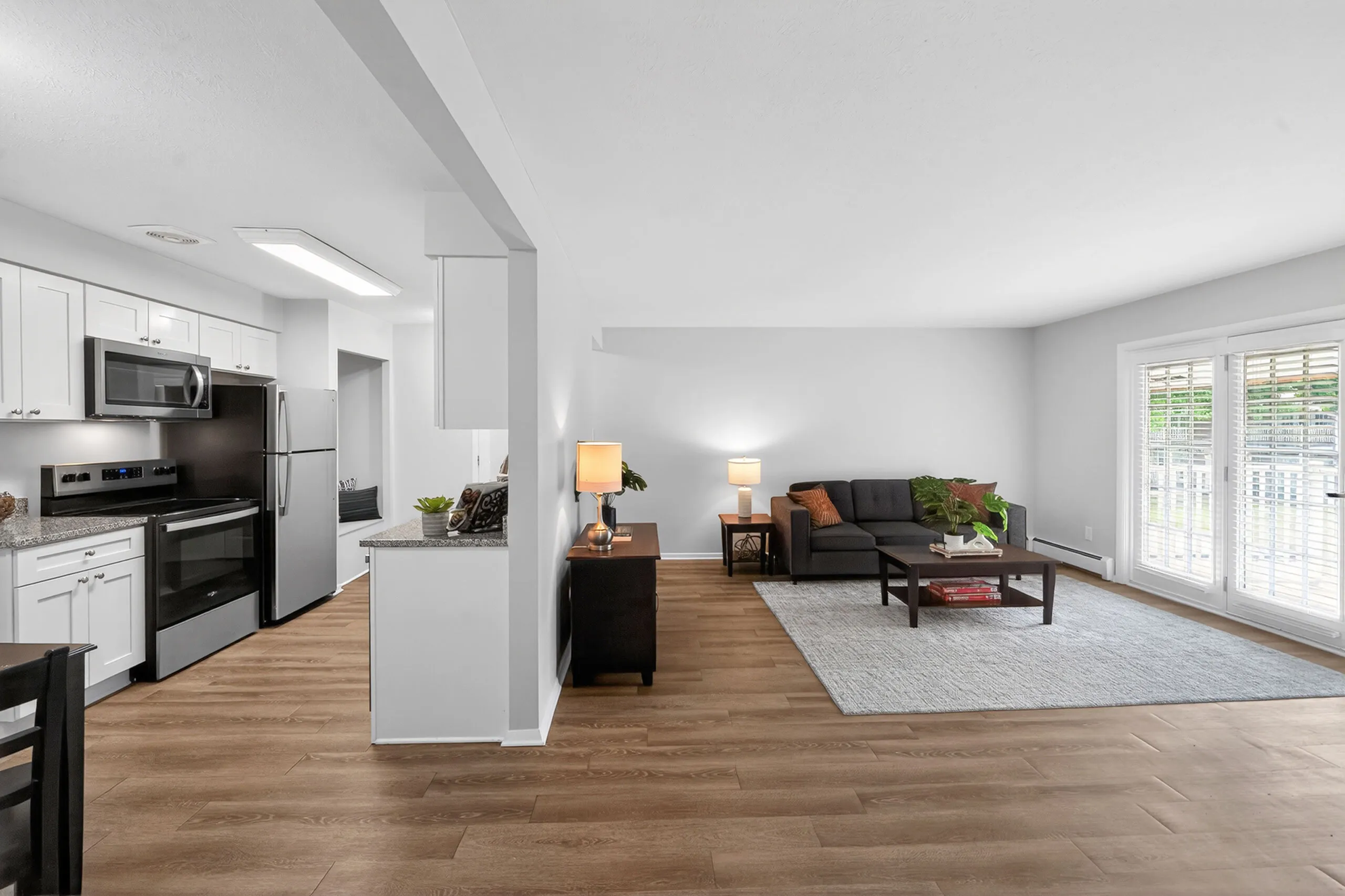 Contemporary open-plan kitchen and living room with sleek appliances, hardwood floors, and abundant natural light.