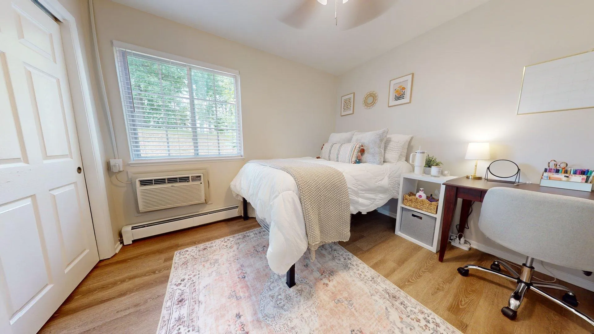 Inviting bedroom with cozy bed, elegant desk, and bright window lighting the space, perfect for relaxation and productivity.
