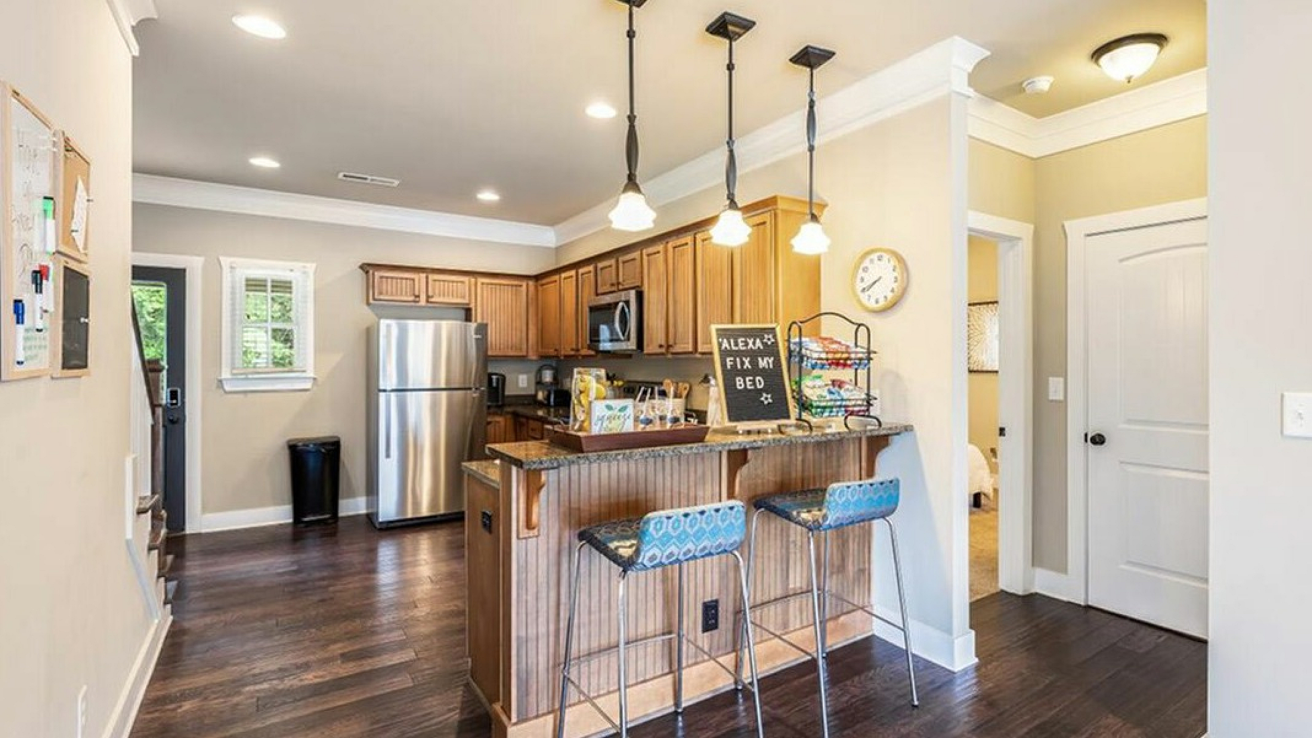 Charming kitchen with modern appliances, sleek wooden cabinetry, and stylish pendant lighting, perfect for entertaining.