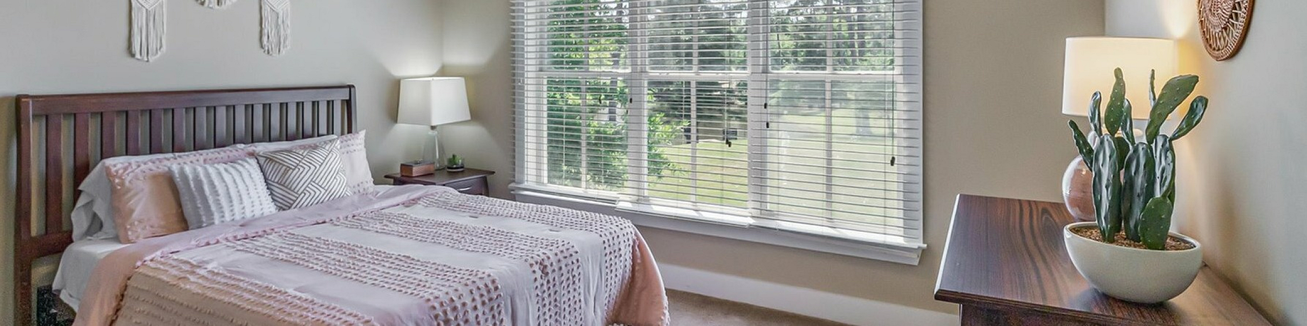 Inviting bedroom bathed in natural light, featuring elegant decor, a plush bed, and serene views from a large window.