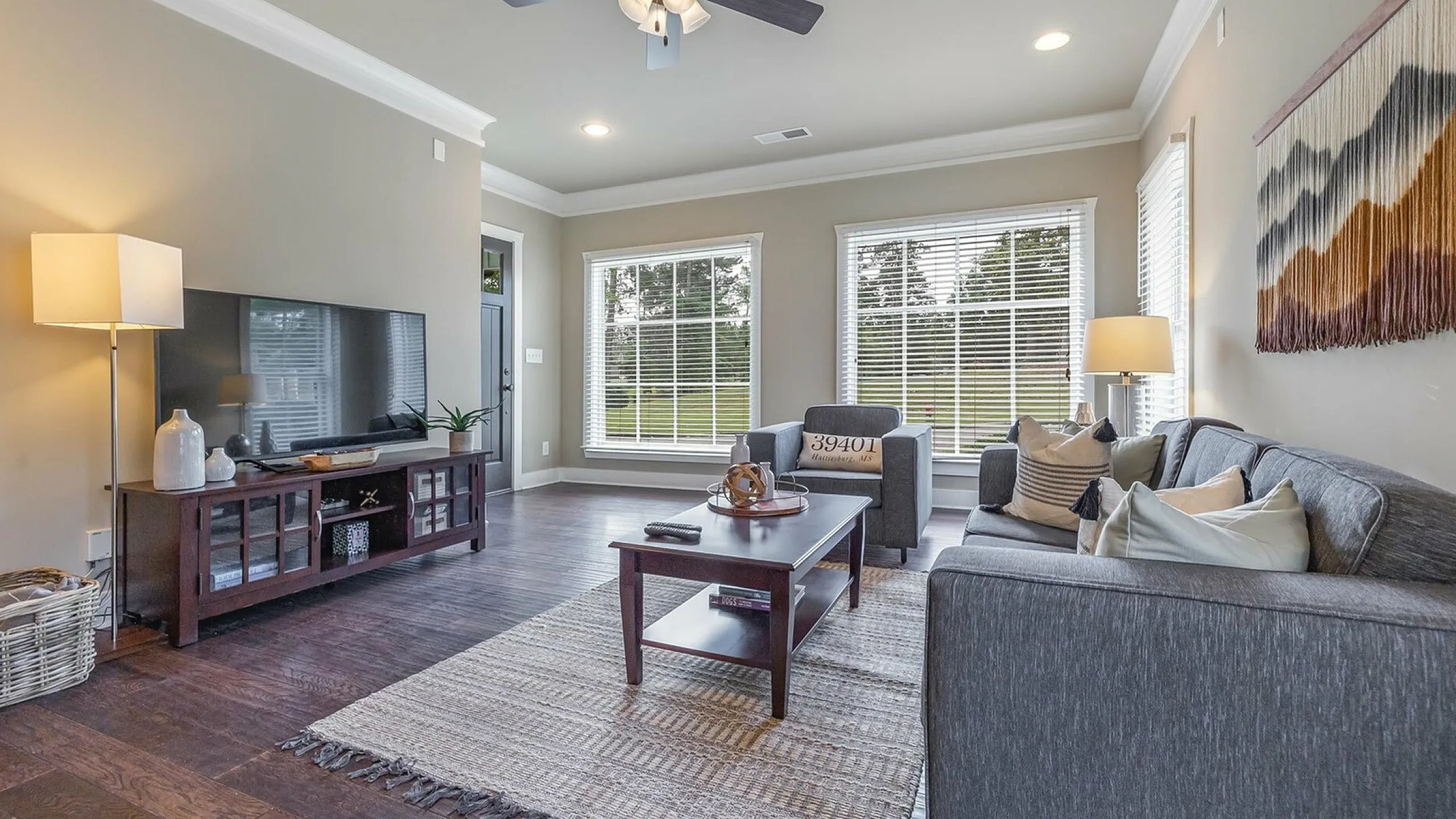 Contemporary living room with cozy gray sofas, stylish decor, and large windows offering natural light and scenic views.