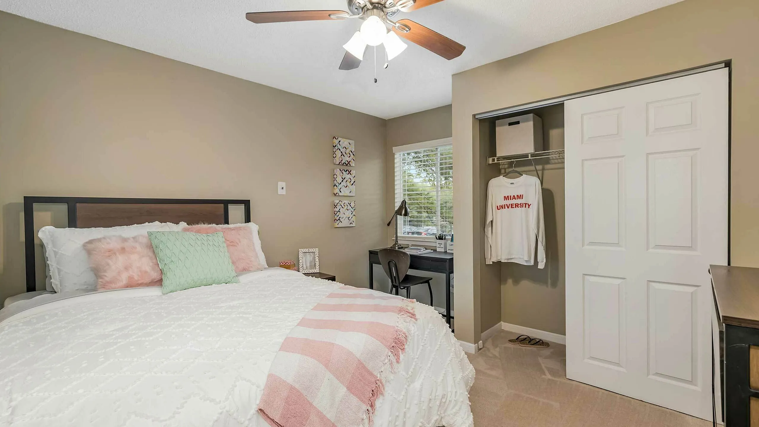 Cozy bedroom with soft lighting, plush bedding, and convenient workspace, perfect for comfort and productivity.