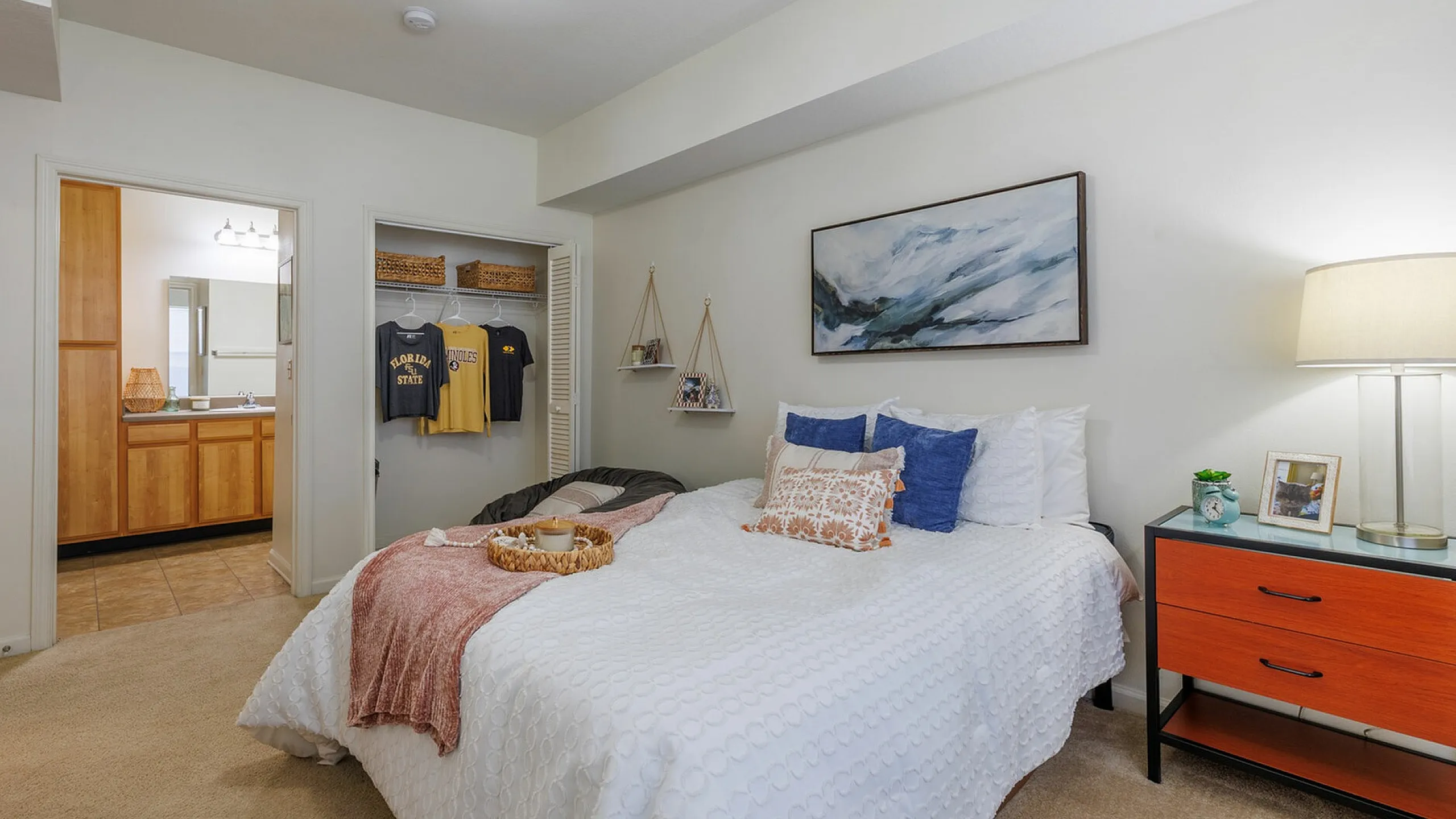 Inviting bedroom with modern decor, featuring a cozy bed with plush pillows, a stylish artwork, and a convenient en-suite bathroom.