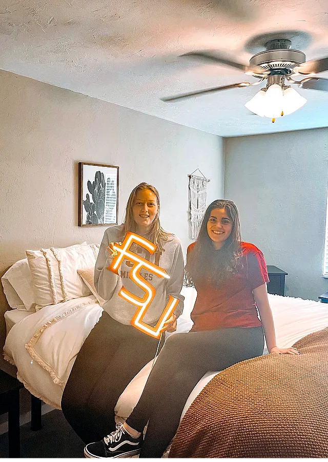 Cozy bedroom featuring a stylish bed, modern ceiling fan, and inviting decor, creating a warm and welcoming atmosphere.
