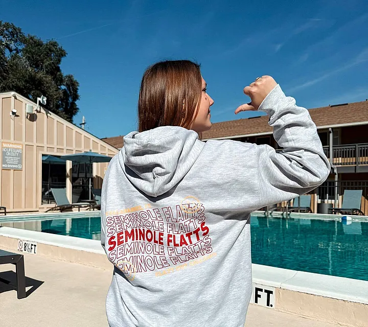 Inviting apartment poolside atmosphere with a relaxing outdoor setting under a clear blue sky.