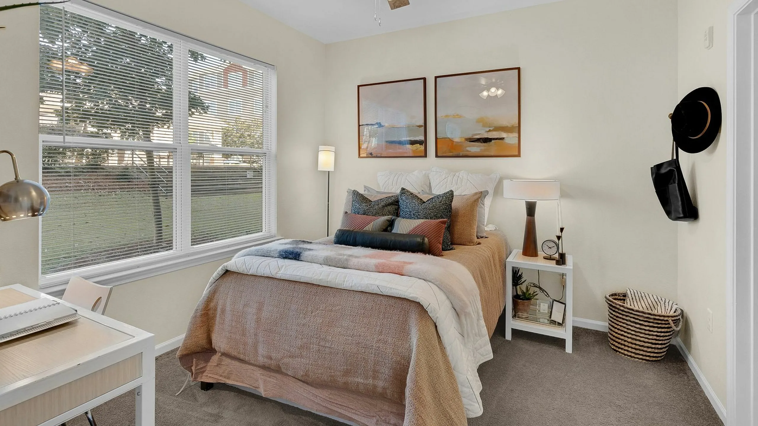 Inviting bedroom with cozy bedding, large window offering scenic views, and stylish decor, perfect for relaxation and comfort.