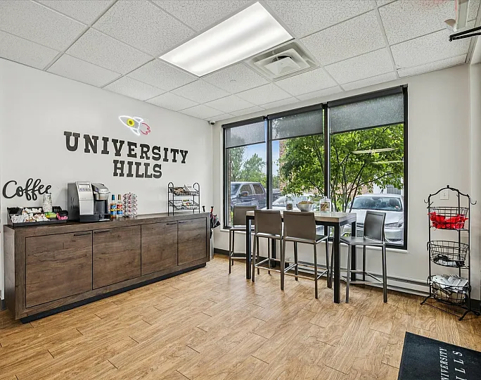 Inviting coffee station at University Hills with modern decor and bright natural light from large windows.