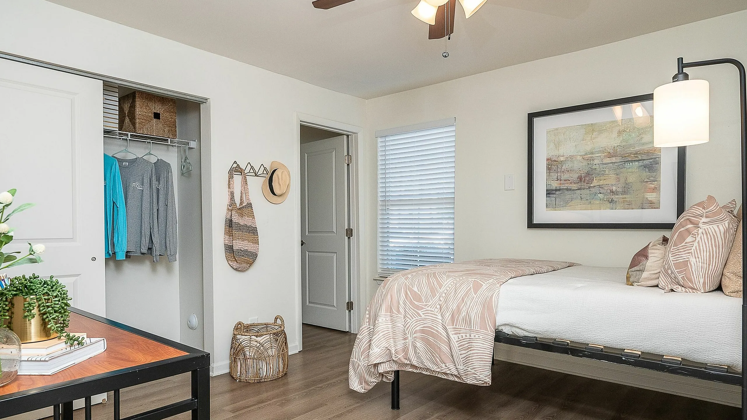 Chic bedroom with modern decor, ceiling fan, and spacious closet in a cozy apartment.