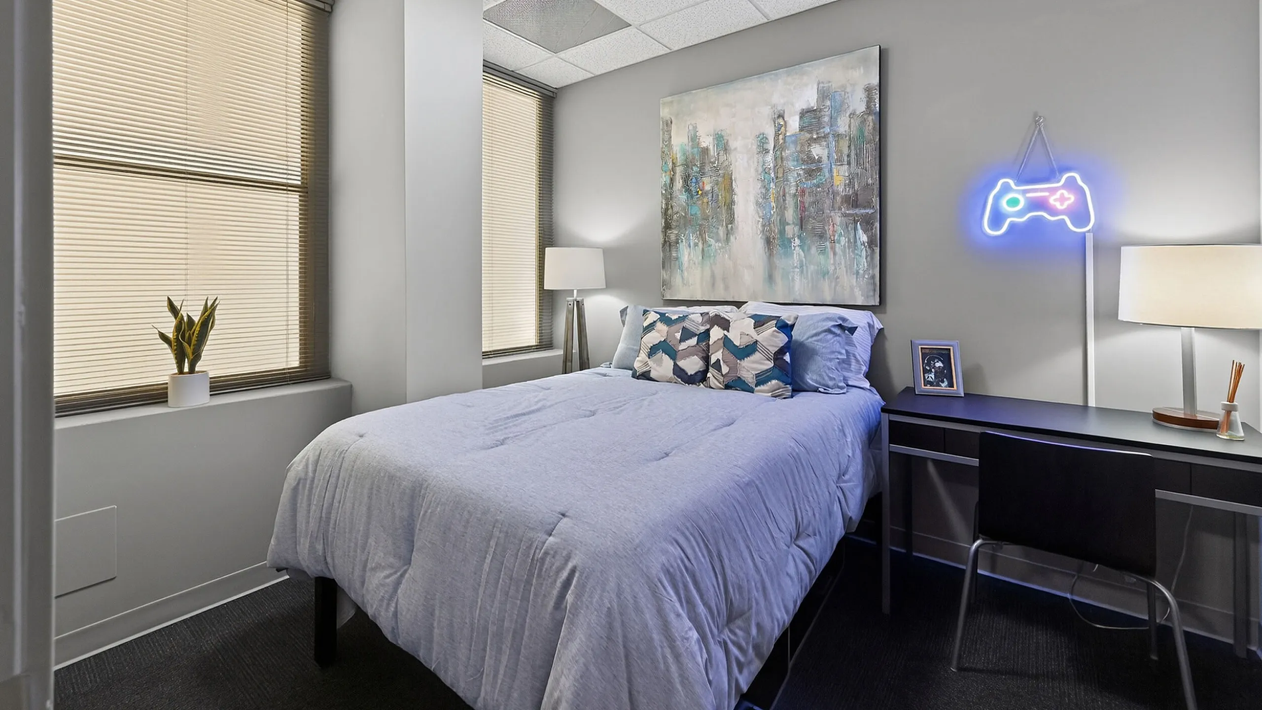 Modern bedroom with sleek decor featuring a plush bed, abstract art, and vibrant neon lighting.