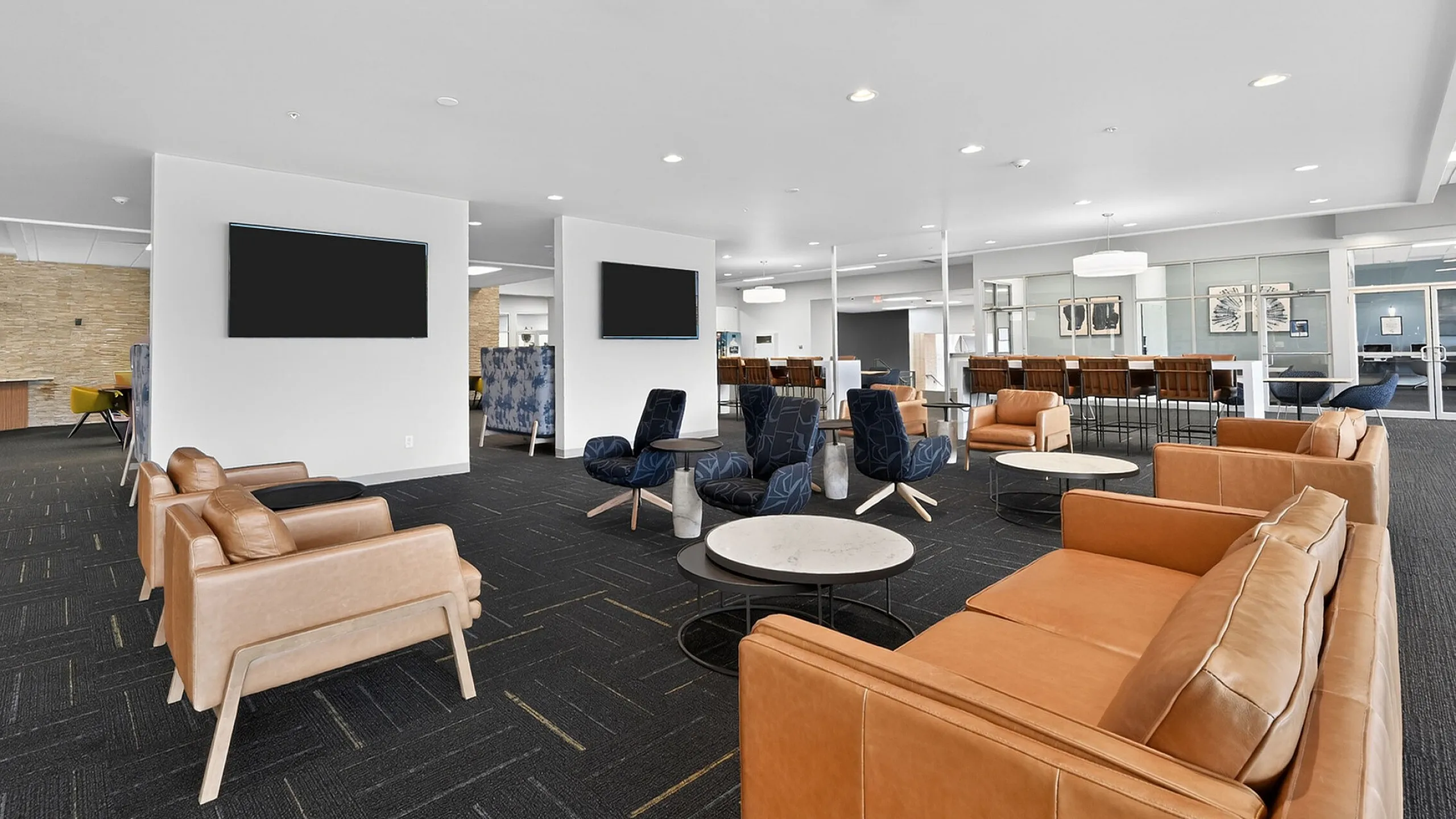 Modern lounge area with stylish leather seating, elegant decor, and ample natural light, perfect for socializing or relaxation.