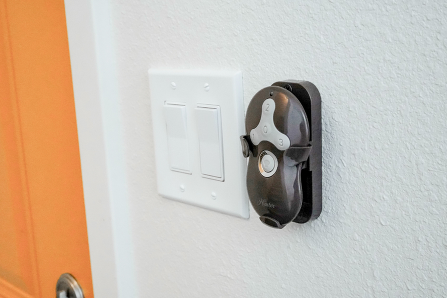 Modern apartment detailing stylish light switches and a sleek wall-mounted fan controller against a textured wall.