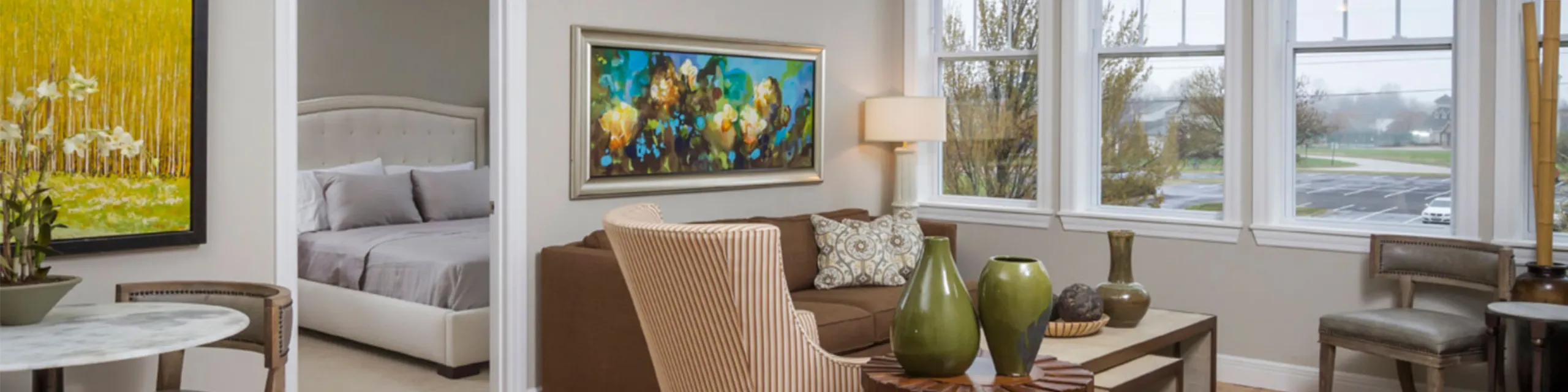 Bright and airy living space at Chesterfield Lofts with large windows, modern decor, and a connected bedroom, showcasing natural light and open layout in a high-end Springfield apartment.