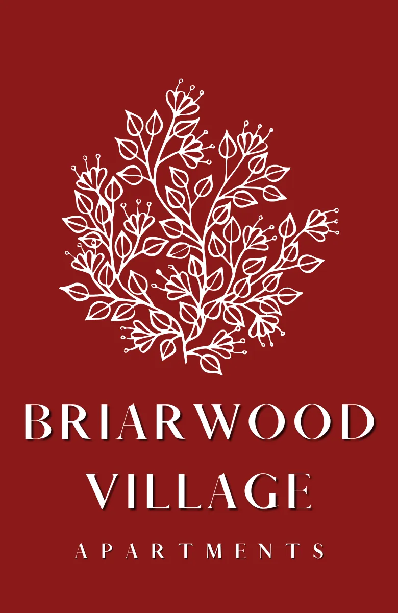 Logo for Briarwood Village Apartments featuring a stylized white botanical illustration of branching leaves and buds centered on a deep red background. Below the graphic, the property name &ldquo;Briarwood Village Apartments&rdquo; appears