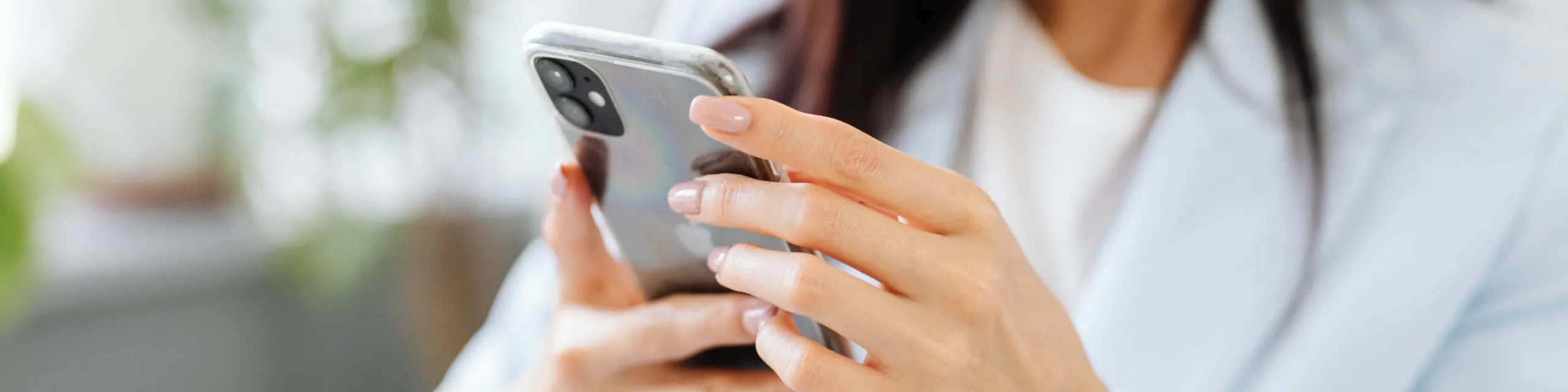 Close-up of a person holding a modern smartphone, showcasing a sleek device design and engagement with technology.