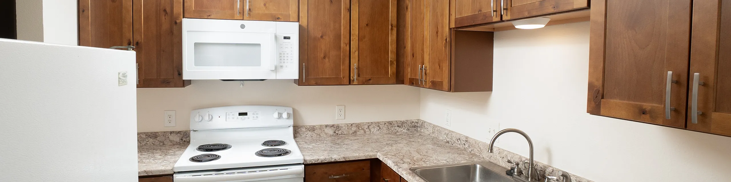 Charming kitchen with warm wood cabinetry, sleek countertops, and modern appliances for a stylish and functional cooking space.