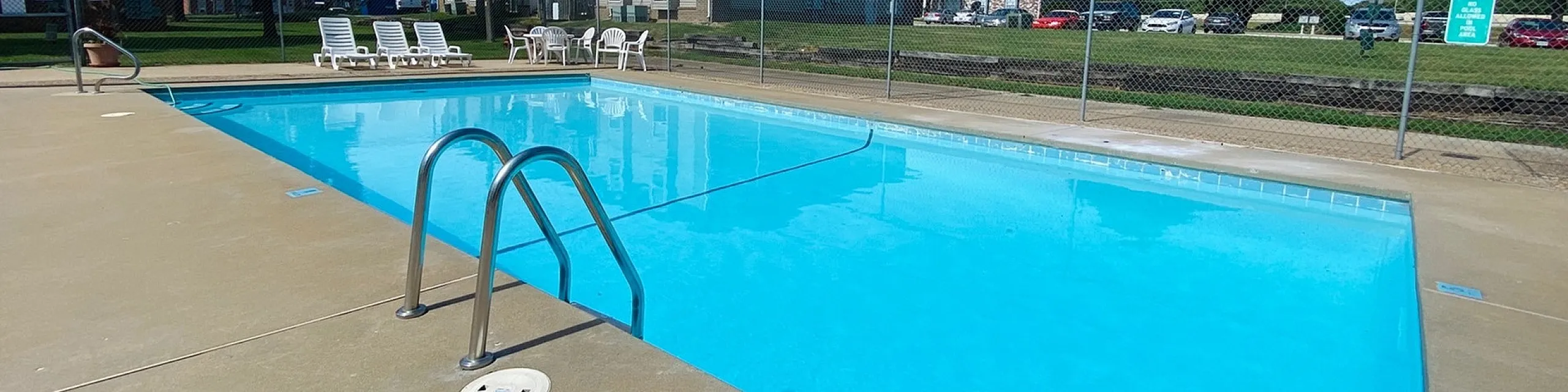 Inviting outdoor swimming pool with sun loungers and a serene atmosphere, perfect for relaxation and leisure.