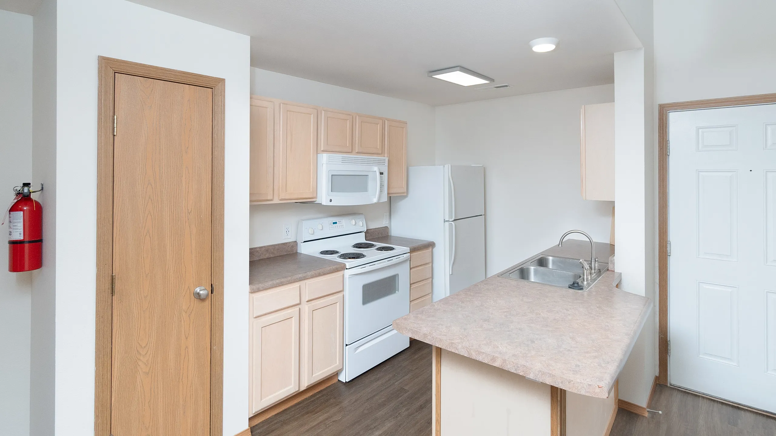 Bright and modern kitchen with sleek wooden cabinets, spacious countertops, and contemporary appliances.