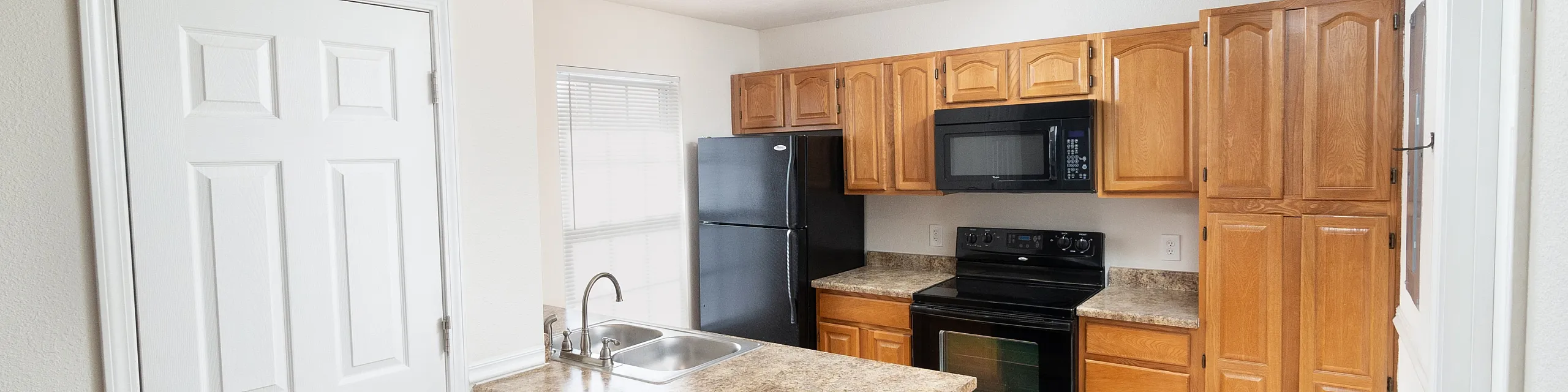 Bright and inviting kitchen with modern appliances, ample wooden cabinetry, and a cozy breakfast bar.