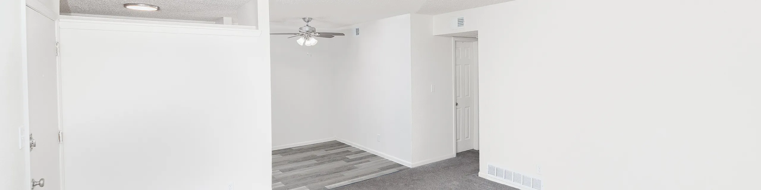 Bright and inviting living space with neutral tones, featuring plush carpeting and modern ceiling fan.