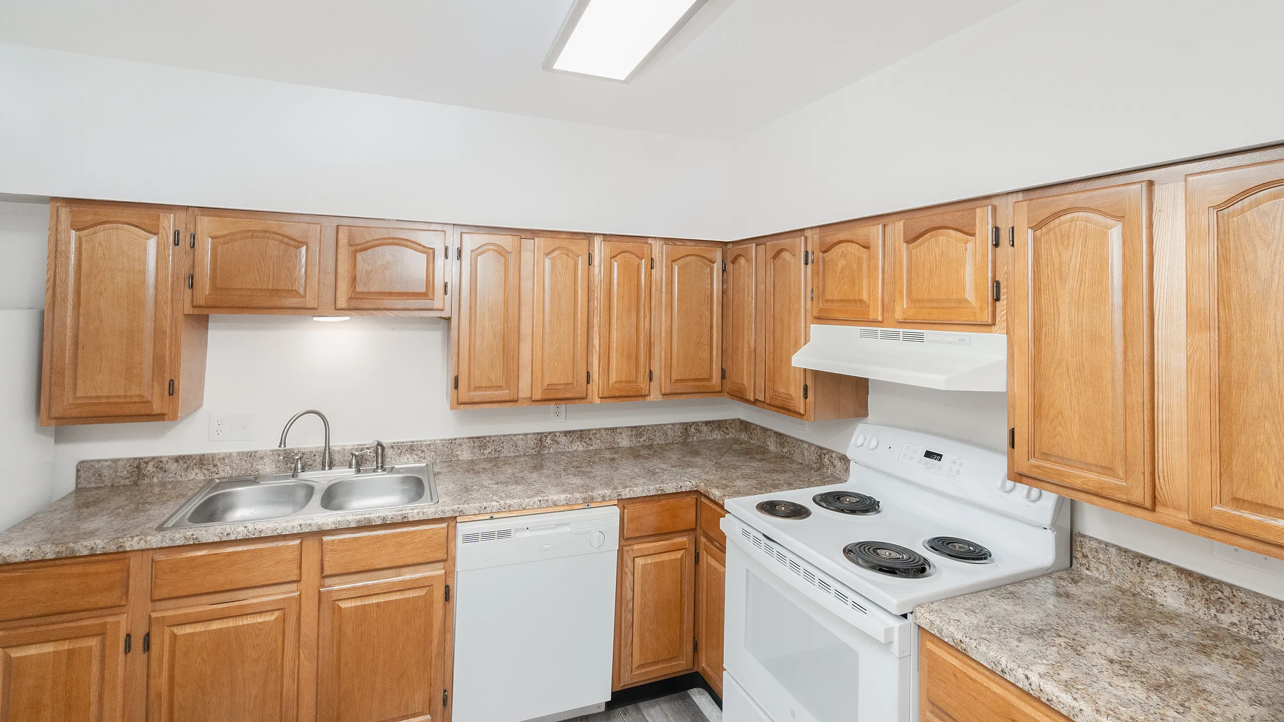 Modern kitchen with elegant wood cabinetry, sleek countertops, and essential appliances for a stylish cooking experience.