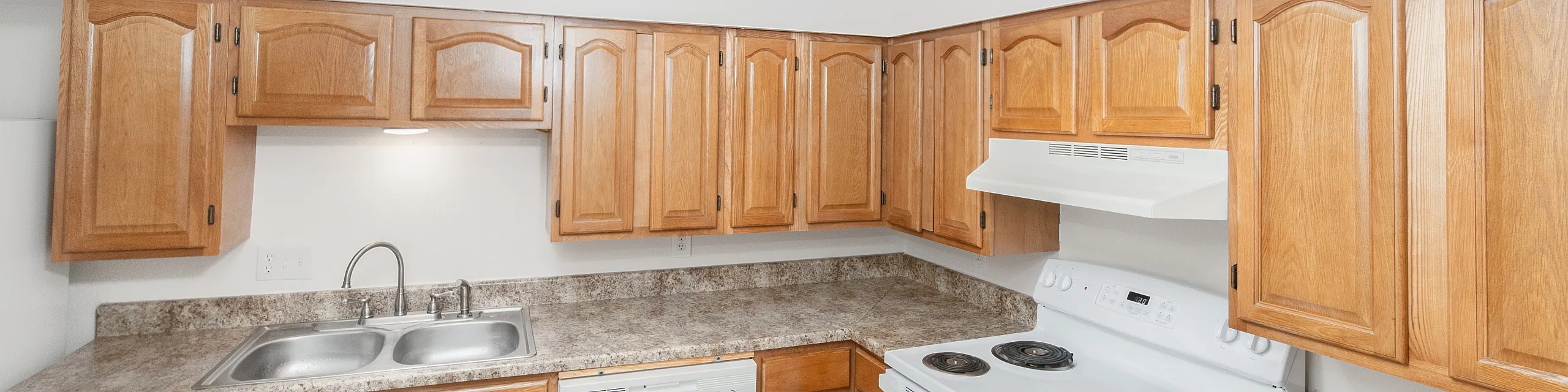 Inviting kitchen with elegant wooden cabinetry, modern appliances, and sleek marble countertops offering functionality and style.