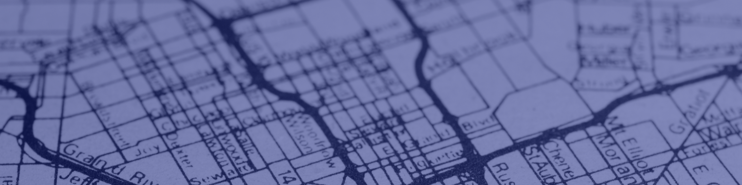 Intricate city map showing detailed grid lines and street names in an artistic blue hue.