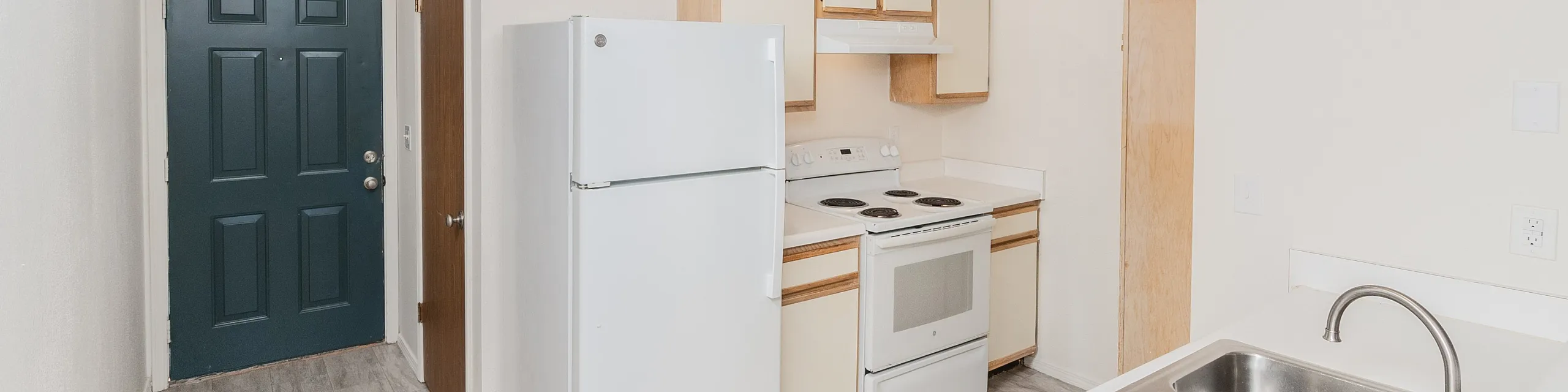 Bright, modern kitchen with sleek white appliances, spacious countertops, and elegant wood cabinetry.