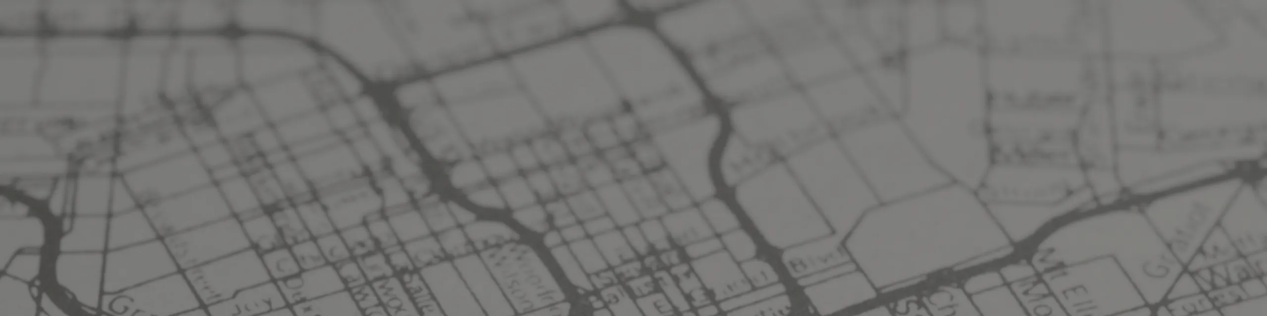 Blurred map background graphic used as a header image, showing abstract street grid and neighborhood layout.