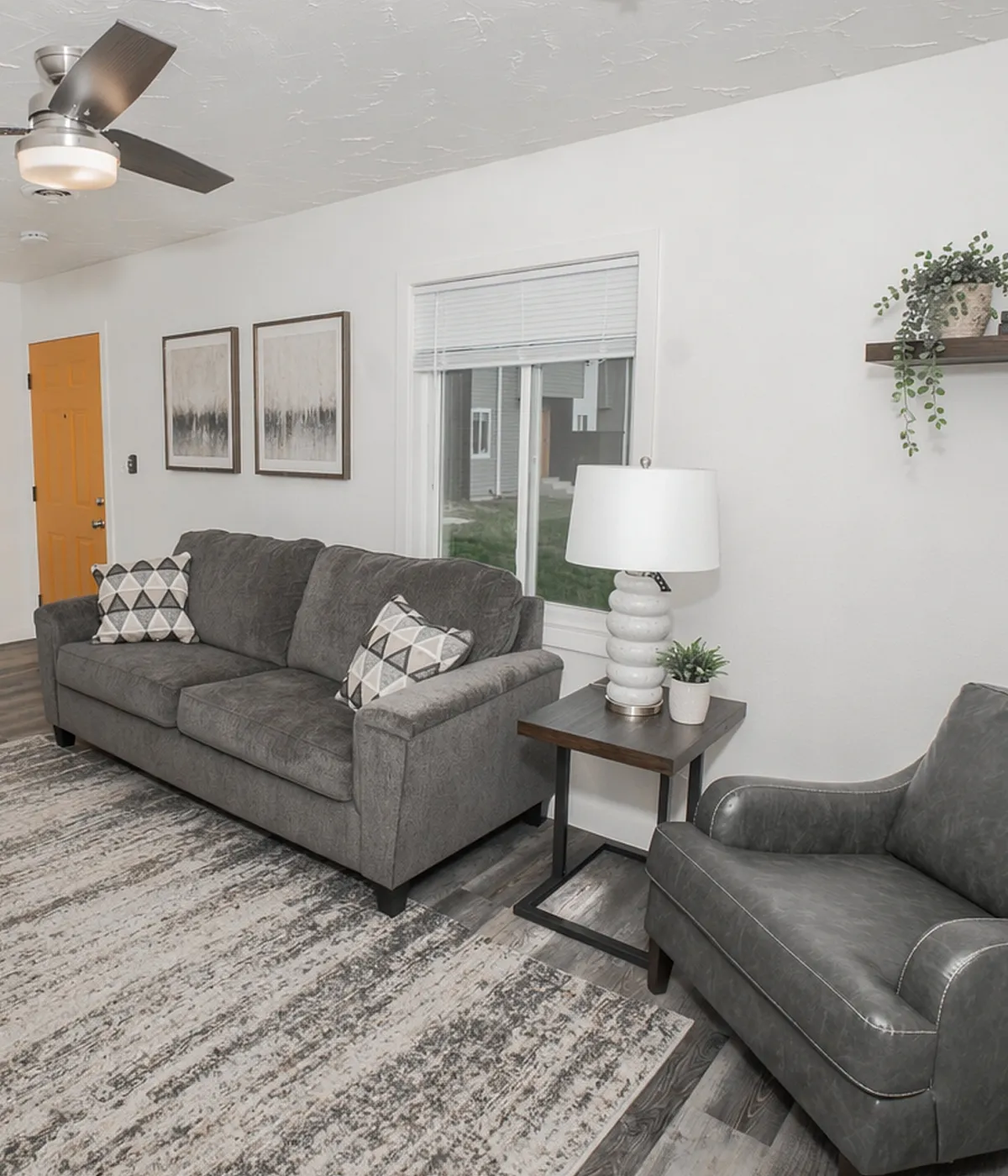 Chic living room with modern gray sofa, elegant armchair, and stylish decor creating a warm and inviting atmosphere.