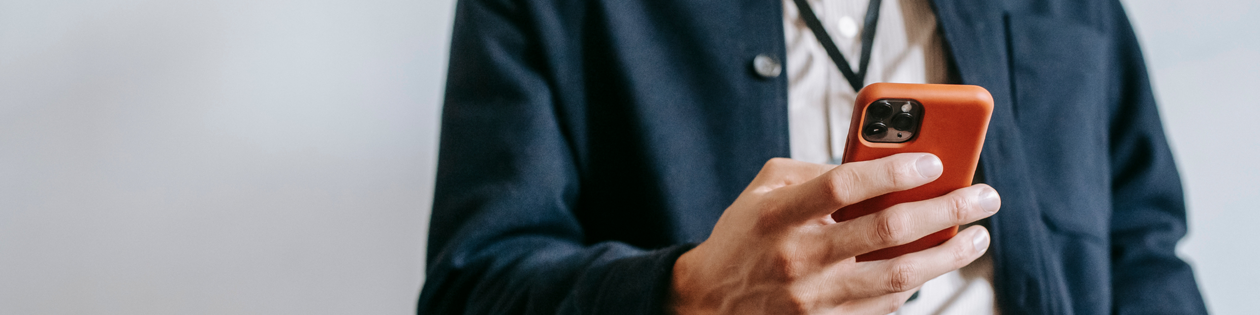 Person holding a modern smartphone in a bright orange case, capturing sleek design and style.