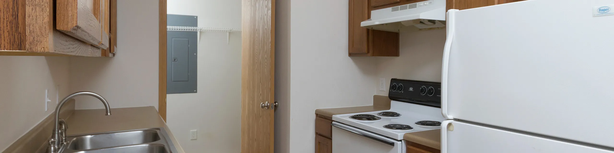Charming kitchen with sleek countertops, wooden cabinetry, and modern appliances in a cozy apartment setting.