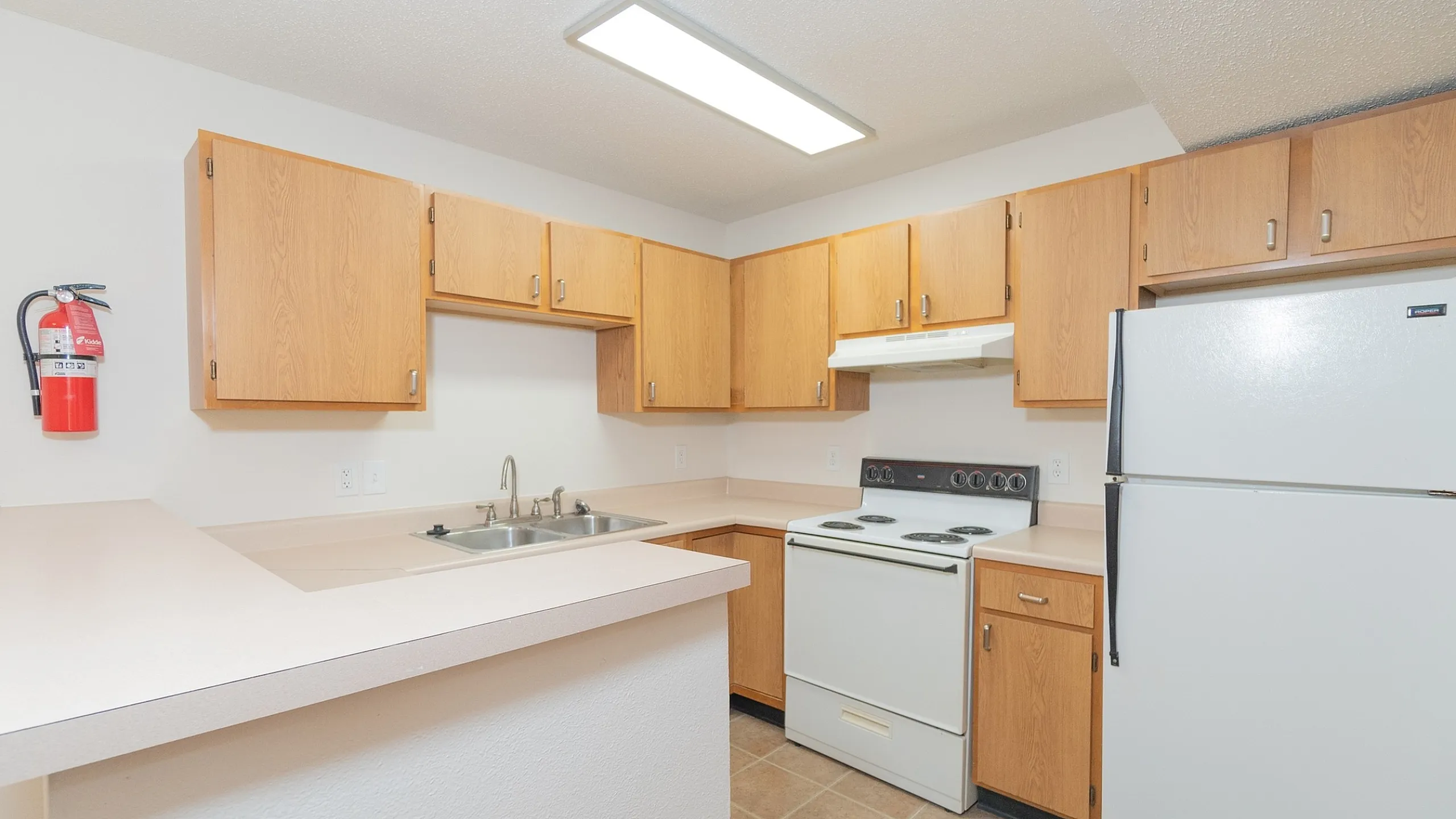 Bright and inviting kitchen with modern appliances, natural wood cabinetry, and ample counter space.