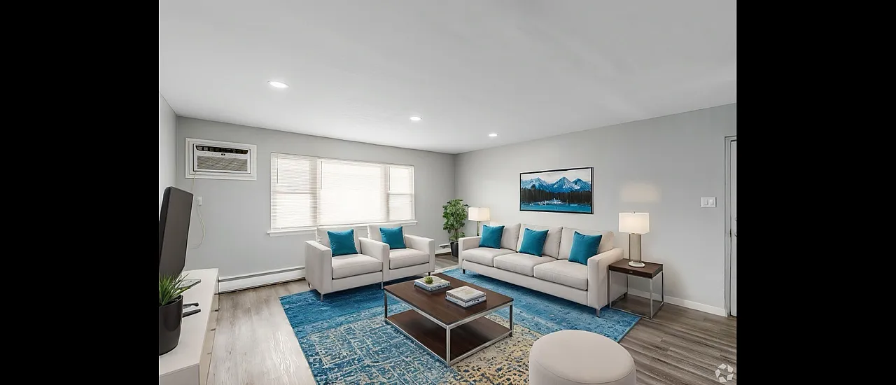 Modern living room with elegant seating, stylish decor, and a vibrant blue rug, offering a cozy and inviting ambiance.