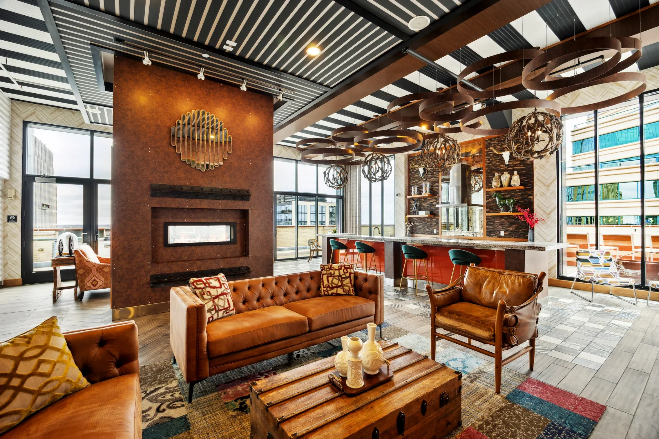 resident lounge including a fireplace, leather sofa, leather chair, and bar space