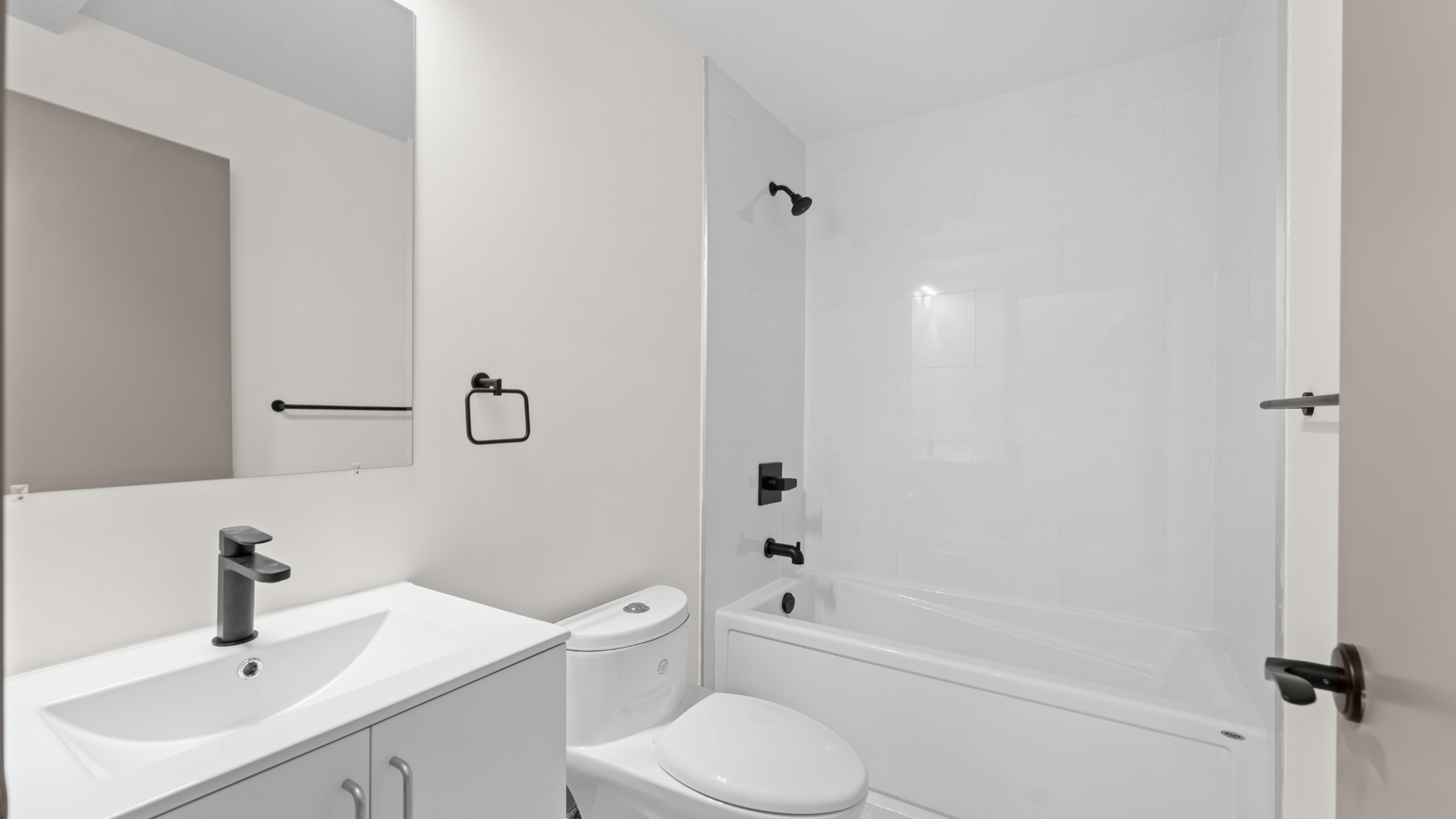 Sleek modern bathroom with stylish fixtures, featuring a spacious bathtub, chic vanity, and a bright, minimalist design.