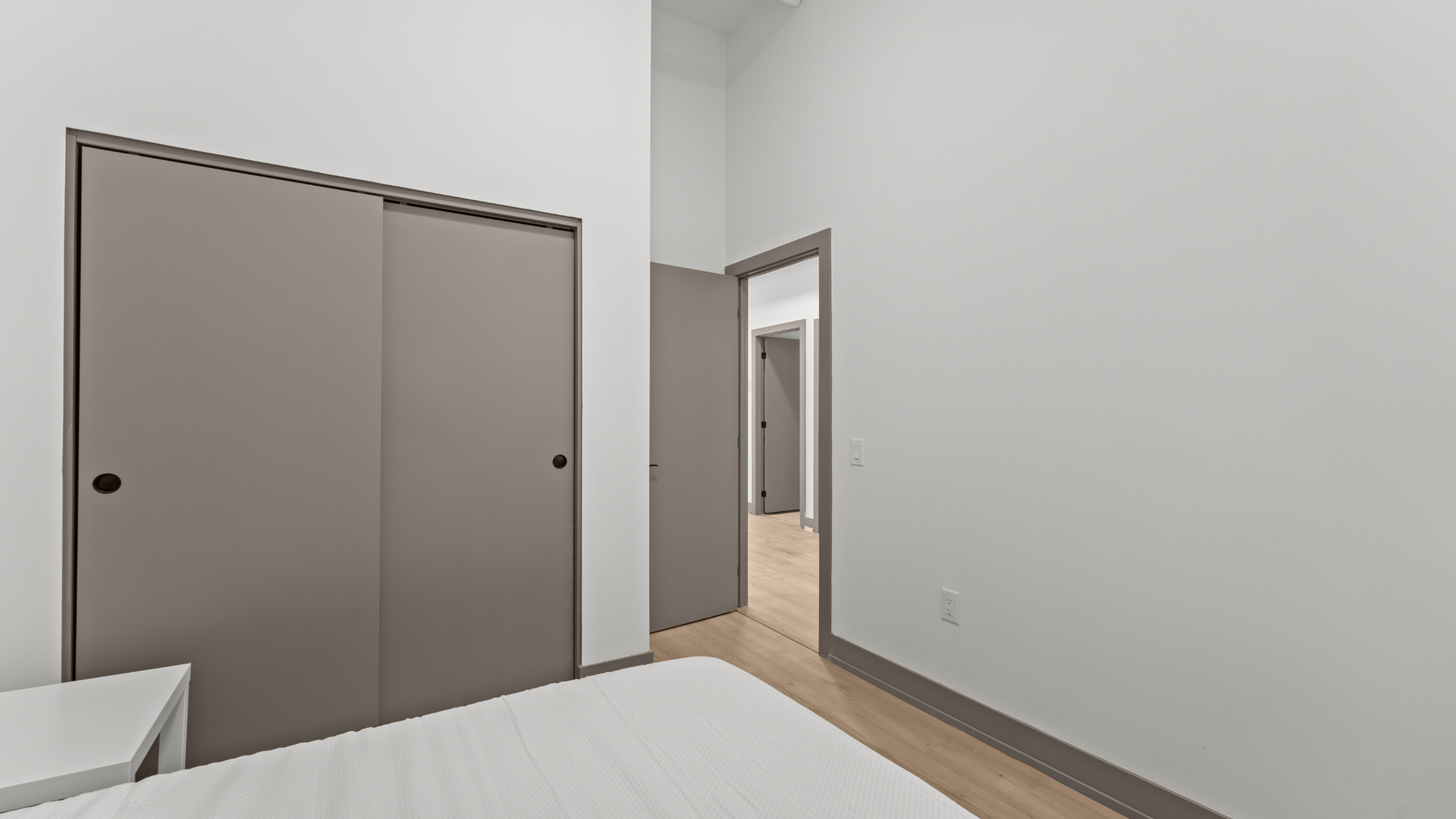 Modern bedroom with sleek sliding closet doors and minimalist design.