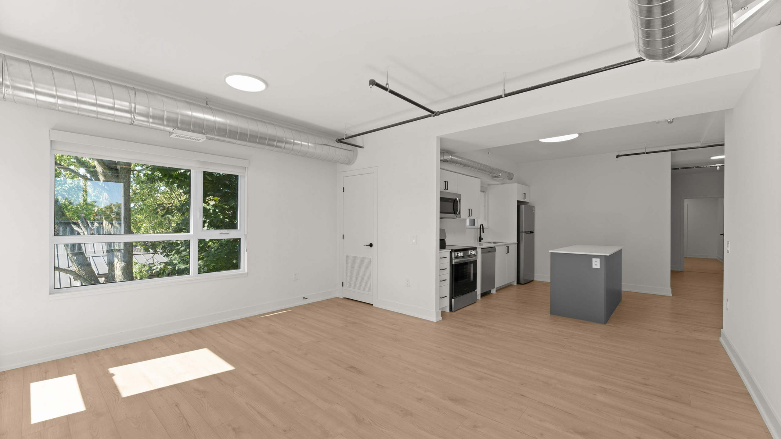 Modern apartment interior featuring open-concept layout with natural light, sleek kitchen, and stylish flooring.