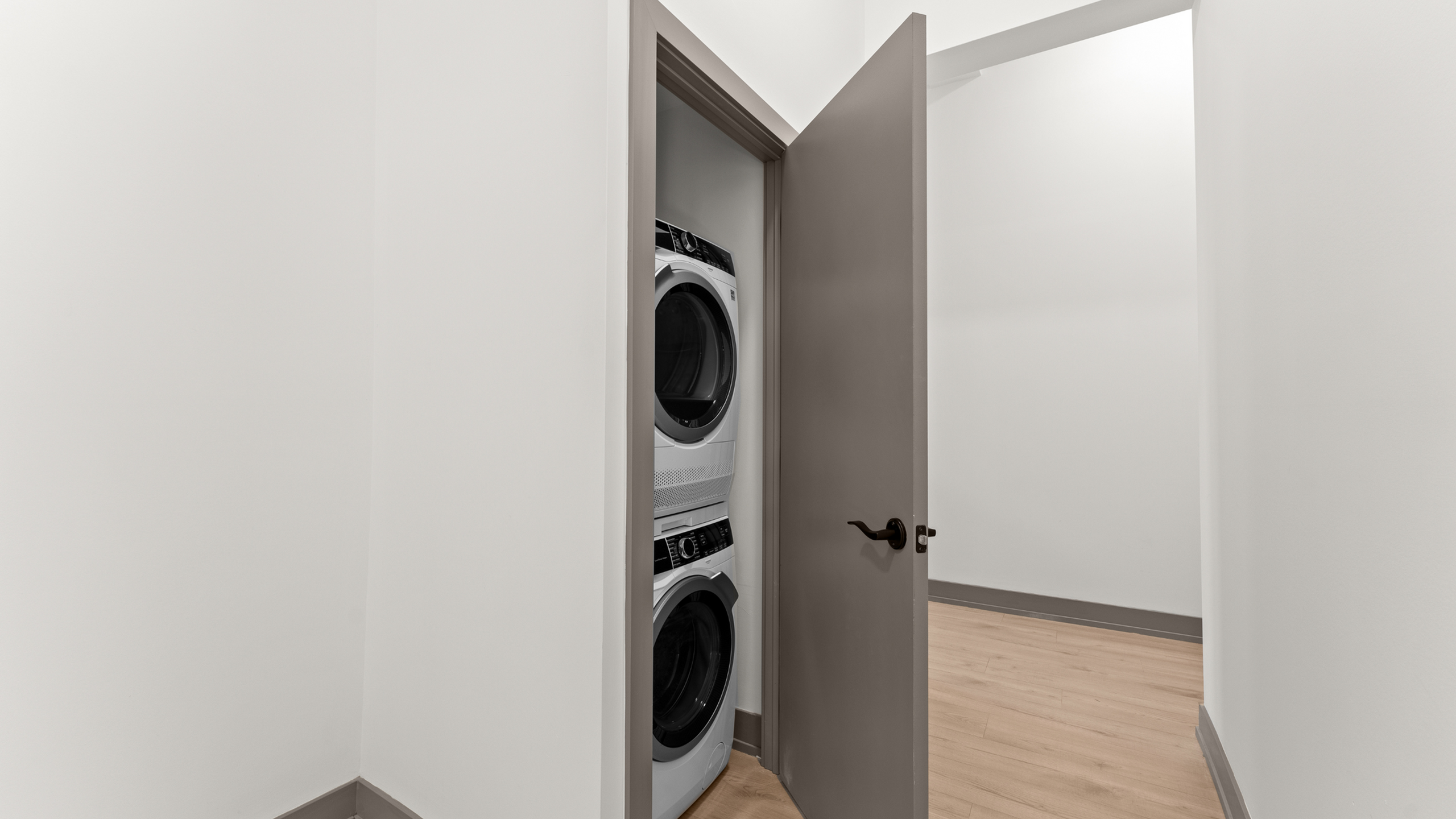 Modern apartment with convenient in-unit stacked washer and dryer, featuring sleek design and efficient use of space.