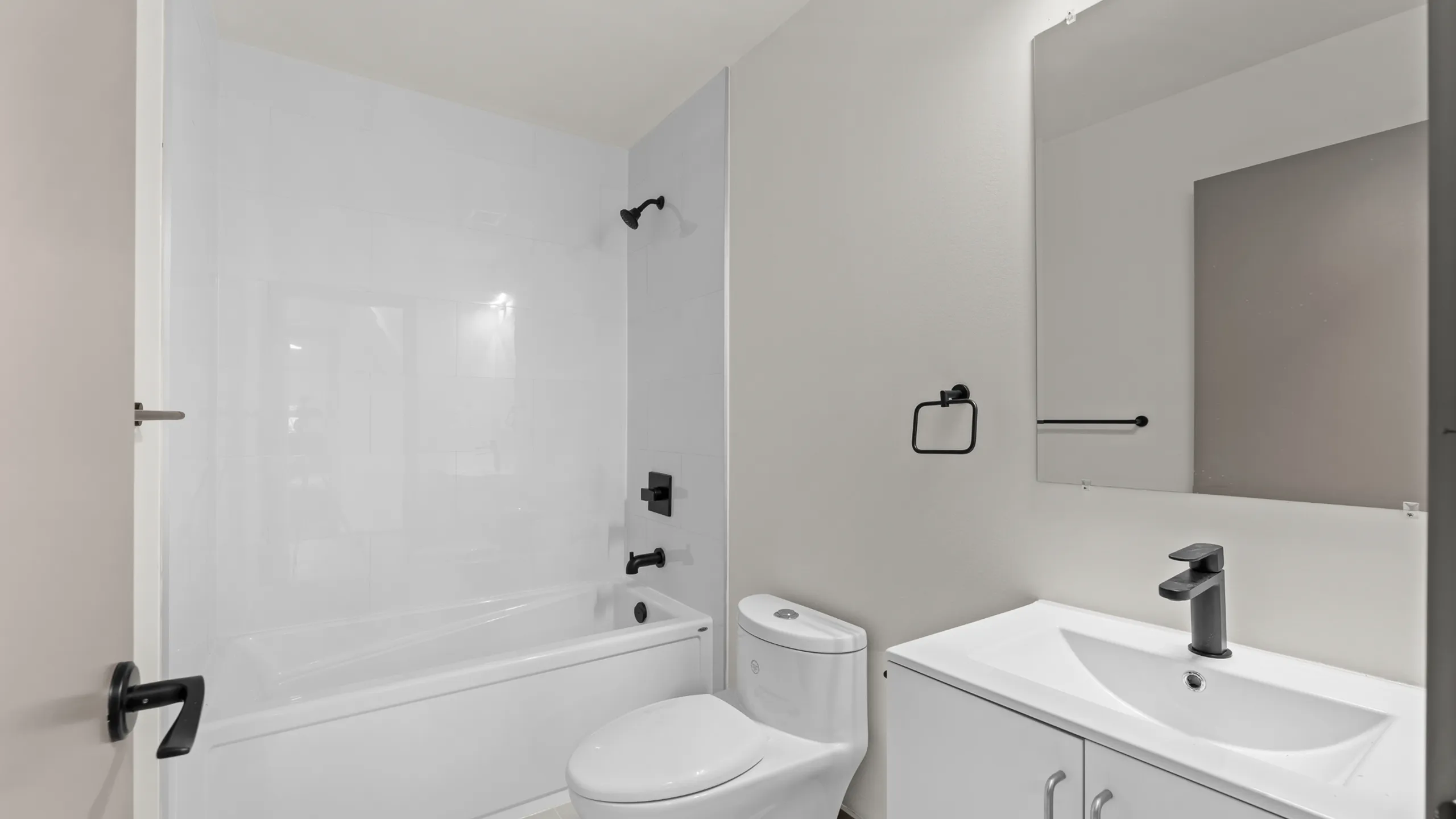 Modern bathroom featuring sleek fixtures, elegant bathtub, and stylish vanity with a large mirror.