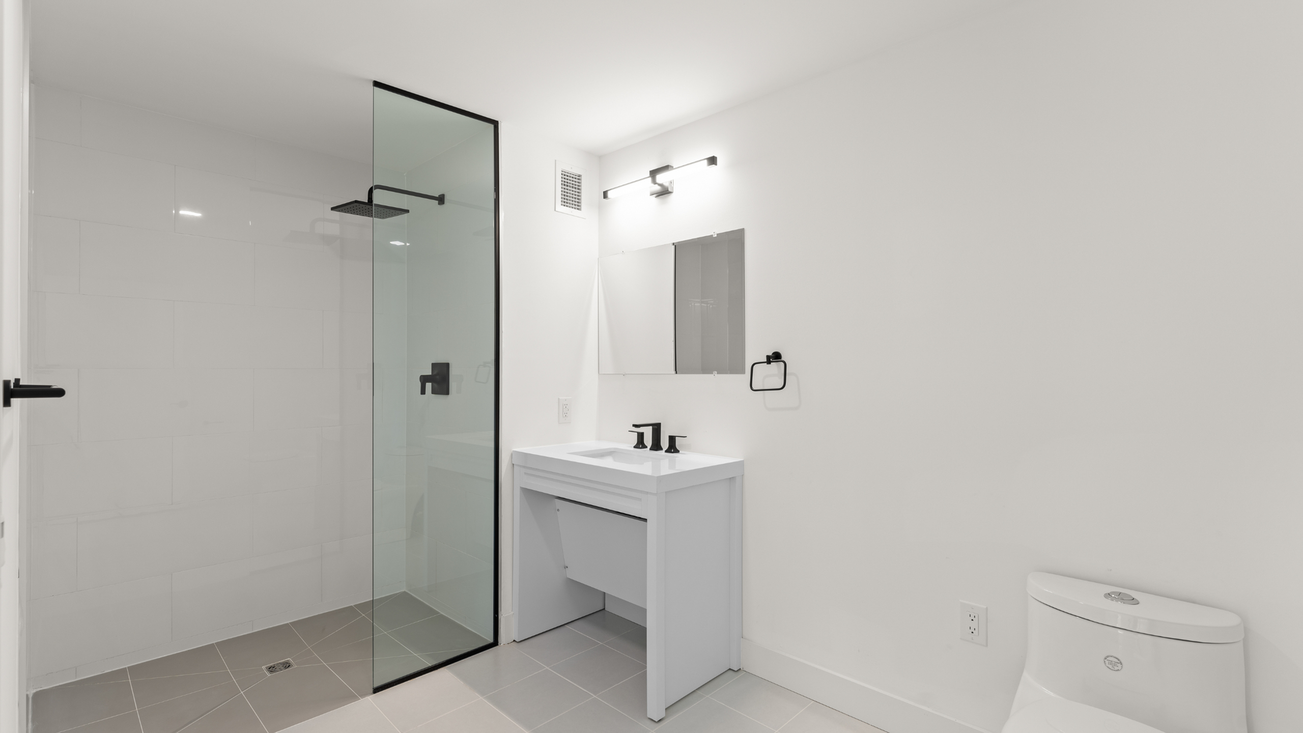 Elegant modern bathroom with sleek glass shower, stylish vanity, and minimalist fixtures.