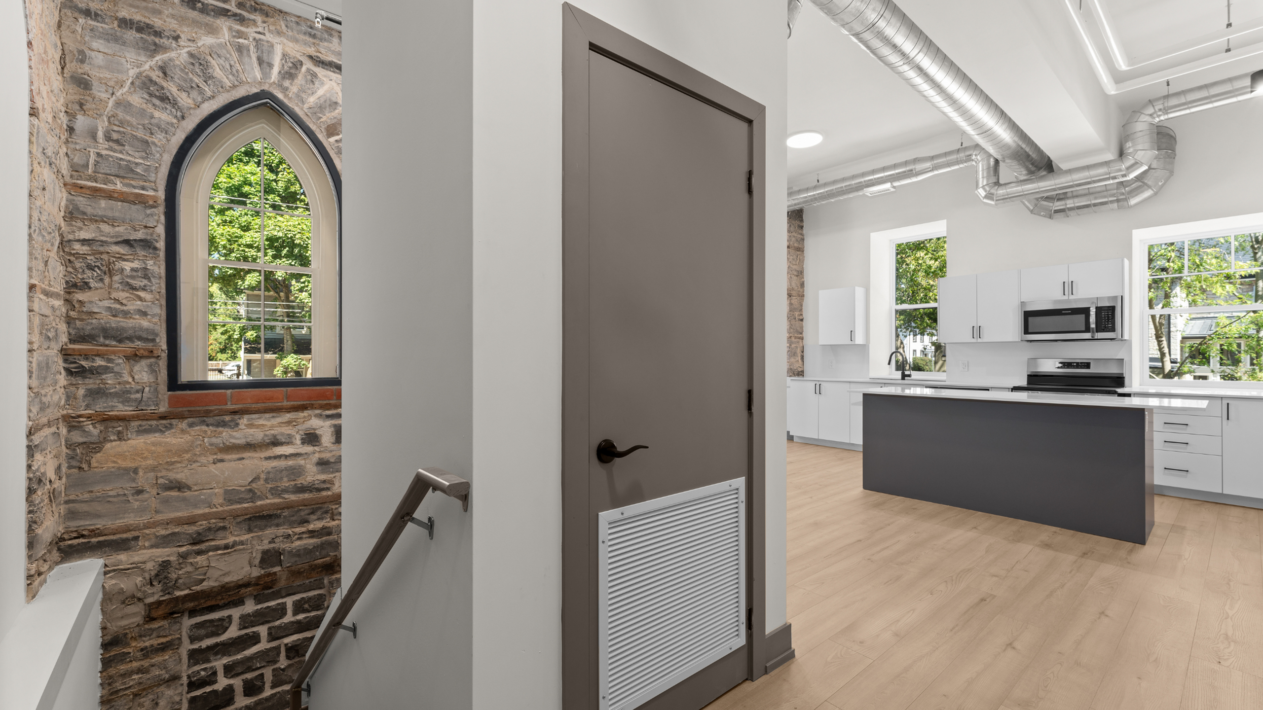 Charming apartment with rustic stone accents, modern kitchen with sleek cabinetry, and inviting natural light.