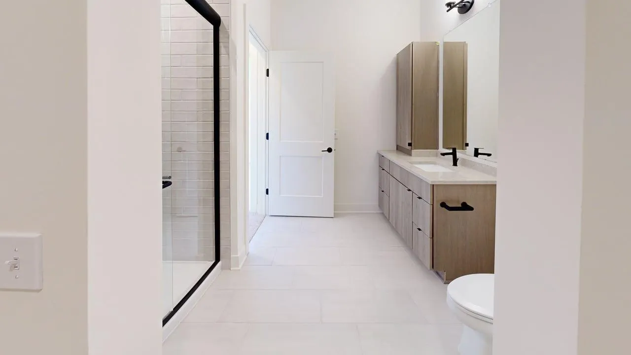 Elegant bathroom featuring modern fixtures, a spacious vanity with dual sinks, and a sleek glass shower enclosure.
