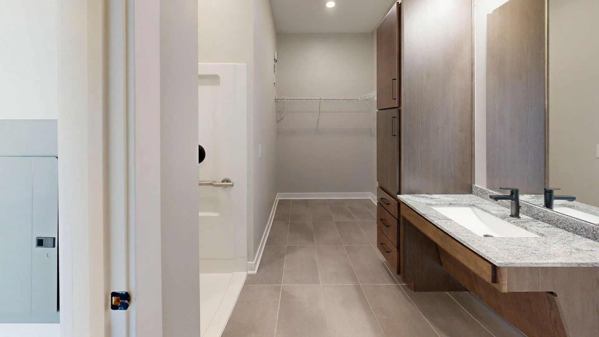 Contemporary bathroom featuring sleek double sinks, elegant cabinetry, and a spacious walk-in shower.