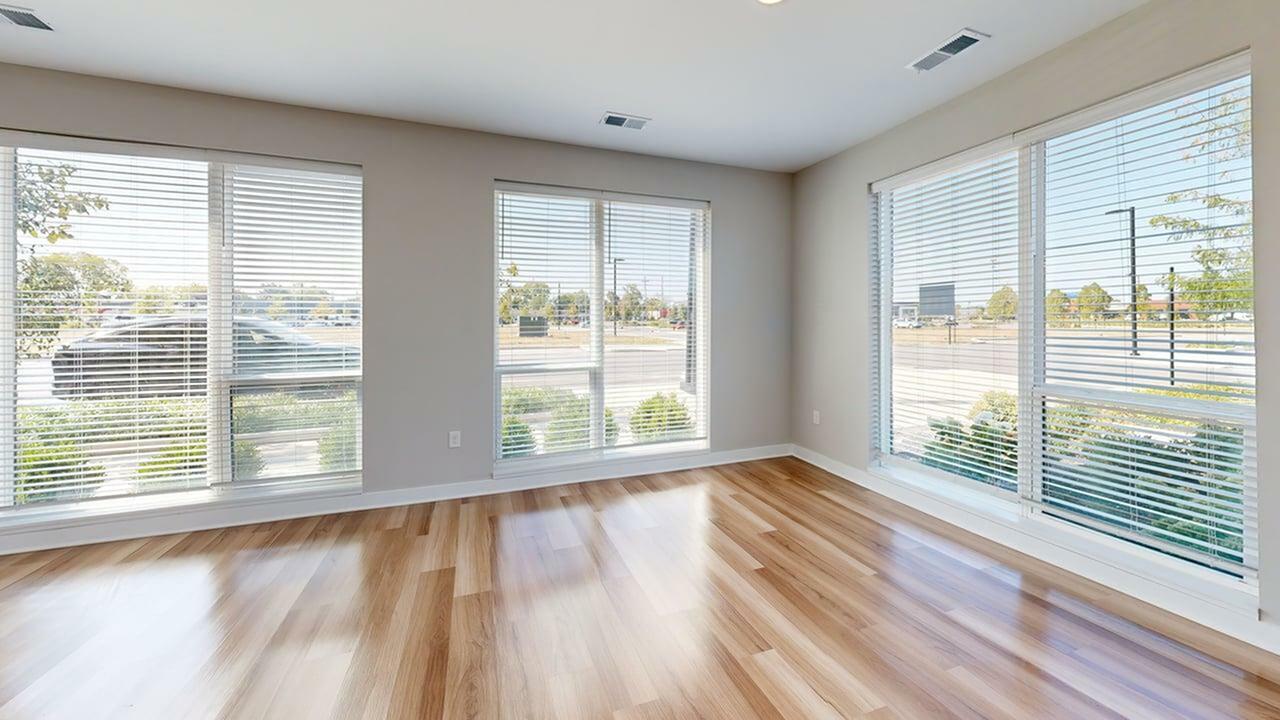 Bright and airy room with large windows, modern wood flooring, and abundant natural light.